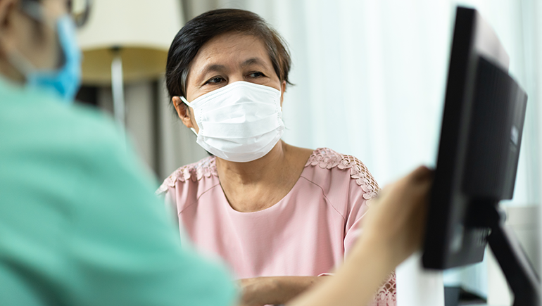 Patient with blood cancer discussing needs with health care provider.